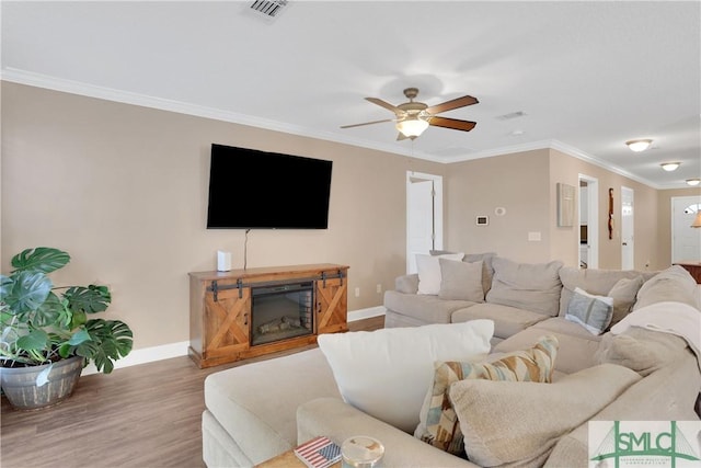 living room with wood-type flooring, ceiling fan, and crown molding