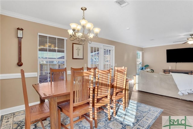 dining area with ceiling fan with notable chandelier, ornamental molding, and hardwood / wood-style floors