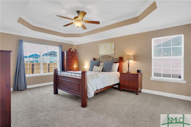 carpeted bedroom featuring a raised ceiling, crown molding, and ceiling fan