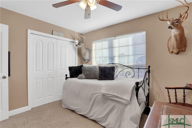 bedroom with ceiling fan, carpet floors, and a closet