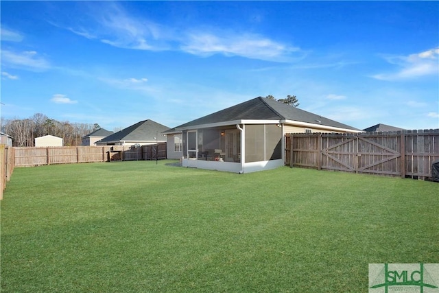 rear view of property featuring a sunroom and a yard