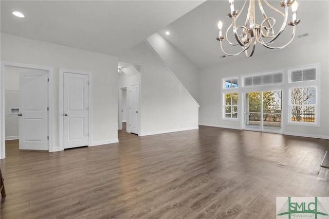 unfurnished living room with an inviting chandelier and dark wood-type flooring