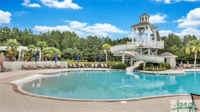 view of pool featuring a water slide and a patio