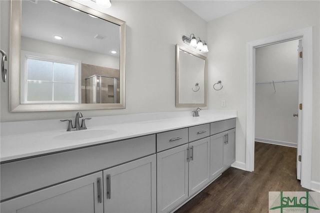 bathroom featuring walk in shower, vanity, and hardwood / wood-style floors