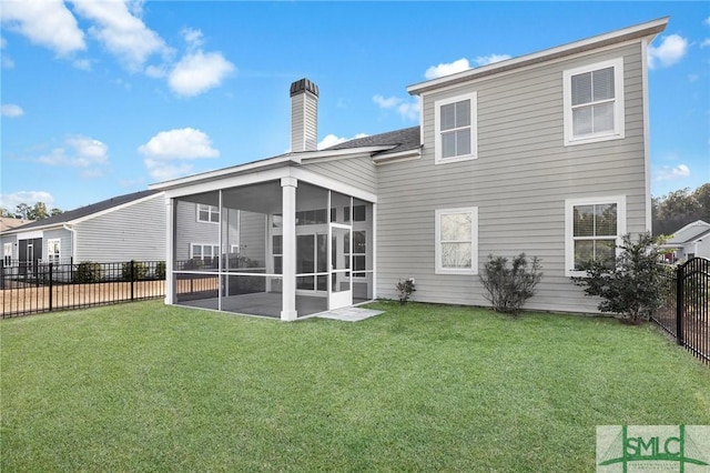 rear view of house featuring a sunroom and a lawn