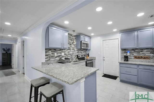 kitchen with decorative light fixtures, appliances with stainless steel finishes, ornamental molding, a sink, and a peninsula