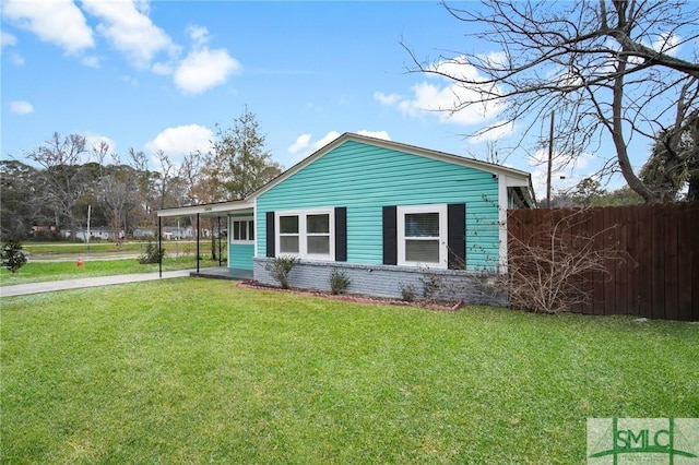 view of front of house featuring a front yard, fence, an attached carport, and brick siding