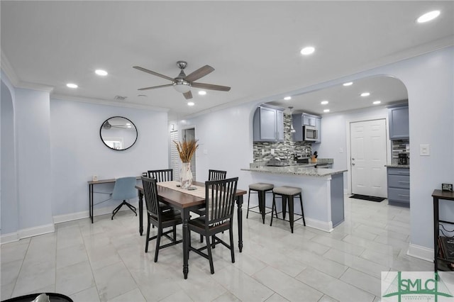 dining area with crown molding, recessed lighting, arched walkways, and ceiling fan