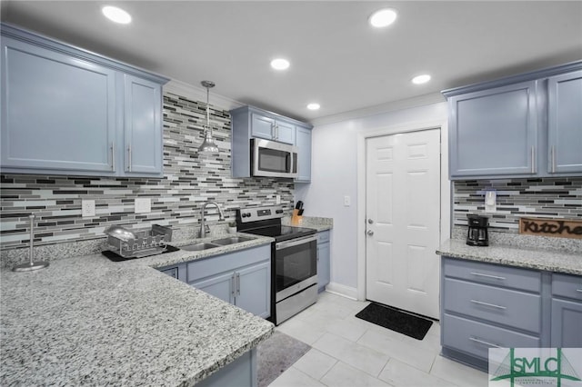 kitchen featuring stainless steel appliances, sink, light stone counters, and decorative light fixtures