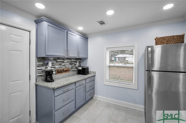 kitchen featuring stainless steel refrigerator, crown molding, light stone countertops, and tasteful backsplash