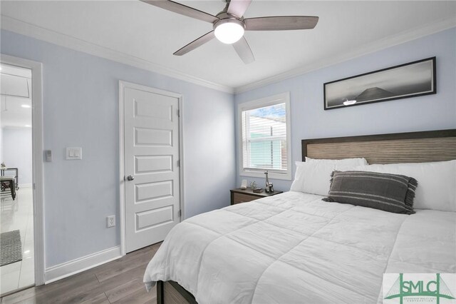 bedroom with crown molding, ceiling fan, and dark hardwood / wood-style flooring