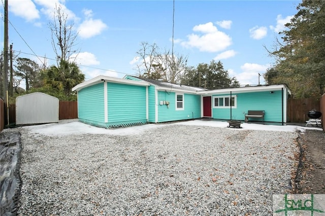 rear view of property featuring a shed and a patio