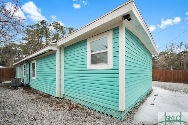 view of side of property featuring cooling unit and fence