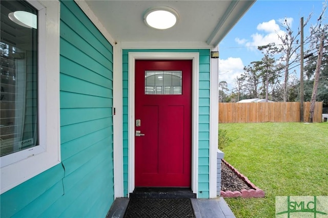 doorway to property with a lawn