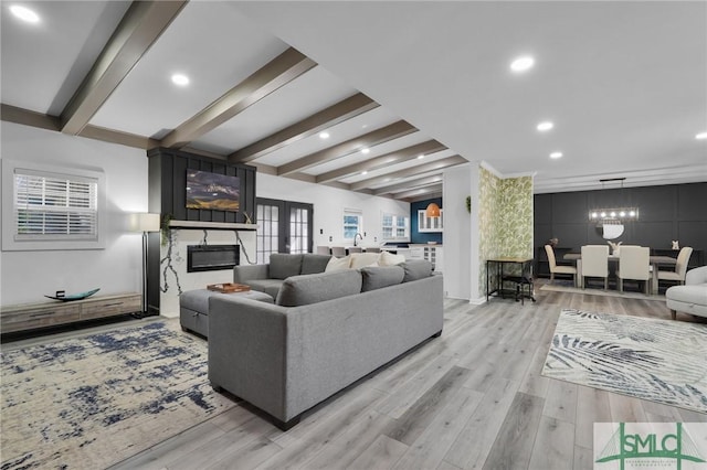 living room with french doors, a fireplace, beam ceiling, and light hardwood / wood-style flooring