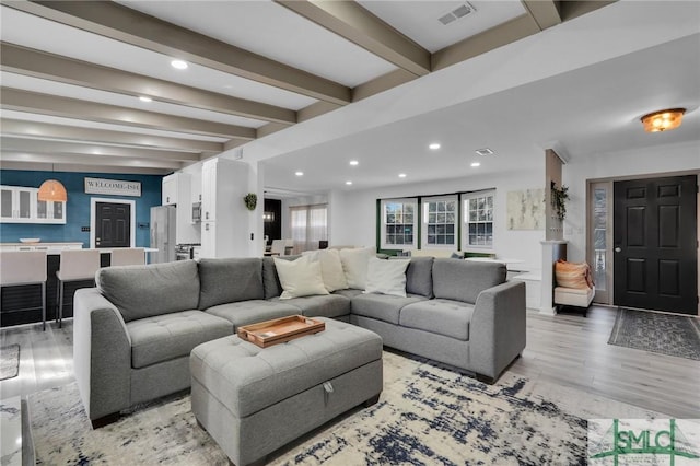 living room with beamed ceiling and light hardwood / wood-style floors