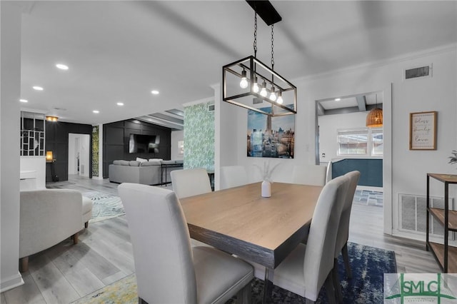 dining room featuring crown molding and light hardwood / wood-style flooring