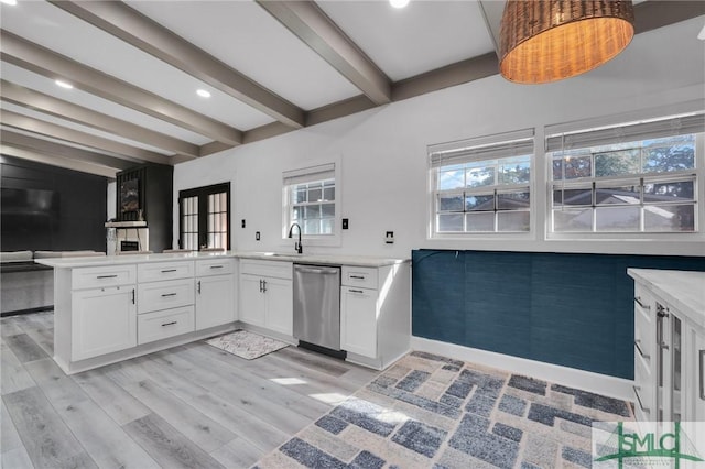 kitchen with beamed ceiling, white cabinetry, dishwasher, sink, and kitchen peninsula