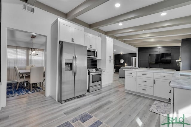 kitchen with appliances with stainless steel finishes, decorative light fixtures, light hardwood / wood-style flooring, and white cabinets