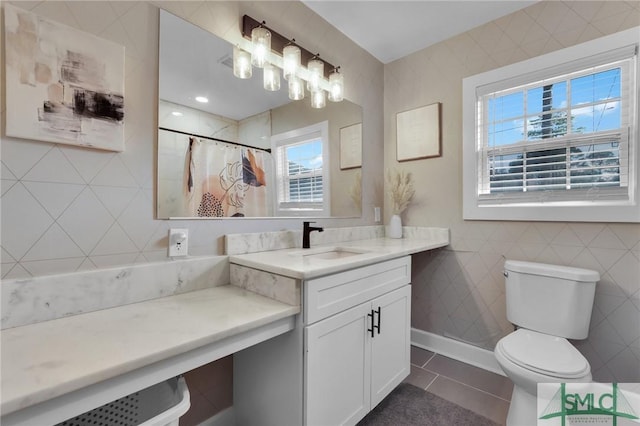 bathroom with tile walls, vanity, a shower with curtain, tile patterned floors, and toilet