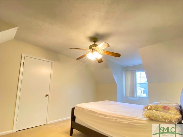 bedroom featuring ceiling fan, lofted ceiling, light carpet, and a textured ceiling