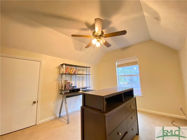 unfurnished office with ceiling fan, vaulted ceiling, and light carpet