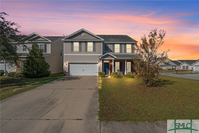 view of front of house featuring a garage and a lawn