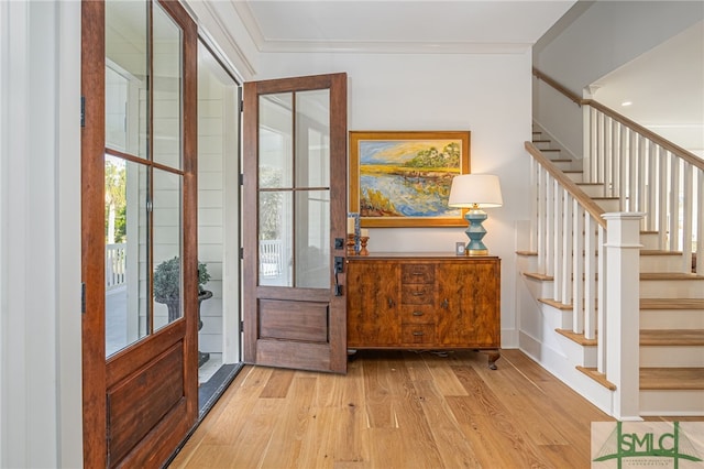 entrance foyer with ornamental molding and light wood-type flooring