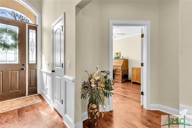 foyer entrance featuring hardwood / wood-style flooring and crown molding