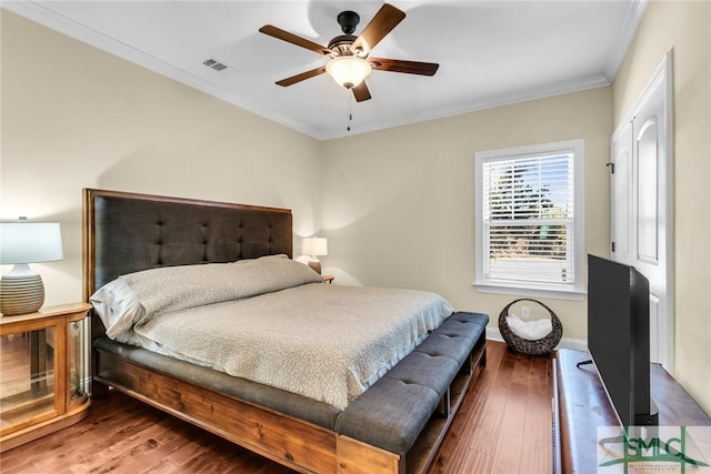 bedroom featuring hardwood / wood-style floors, crown molding, and ceiling fan