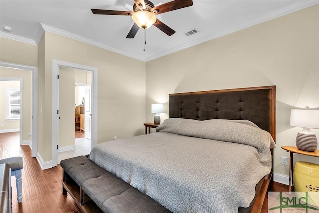 bedroom featuring hardwood / wood-style flooring, crown molding, and ceiling fan