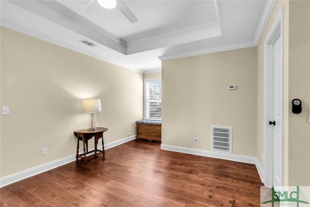 unfurnished room featuring a raised ceiling, crown molding, ceiling fan, and dark hardwood / wood-style flooring