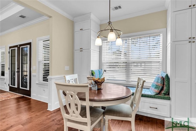 dining area featuring crown molding, dark hardwood / wood-style floors, and french doors