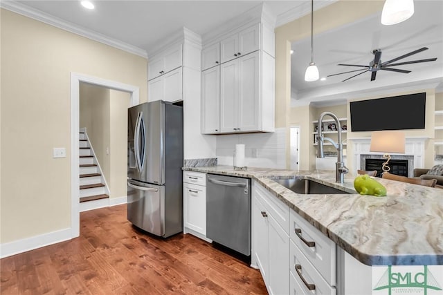 kitchen with sink, stainless steel appliances, hanging light fixtures, and white cabinets