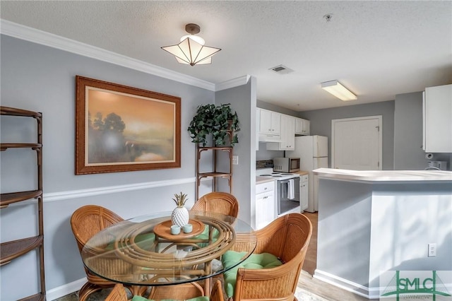 dining room with ornamental molding and a textured ceiling