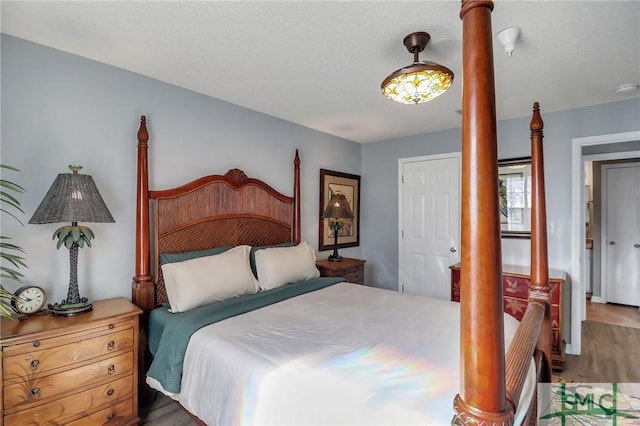 bedroom featuring decorative columns and wood-type flooring