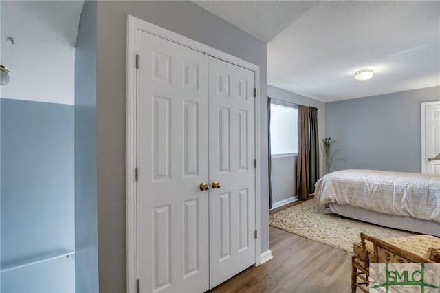 bedroom with hardwood / wood-style floors and a closet