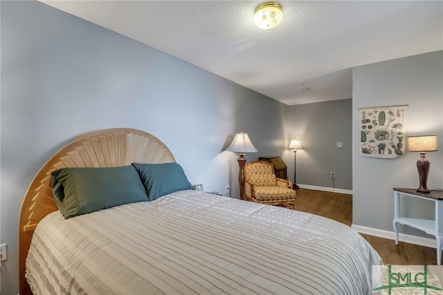 bedroom with wood-type flooring and a textured ceiling