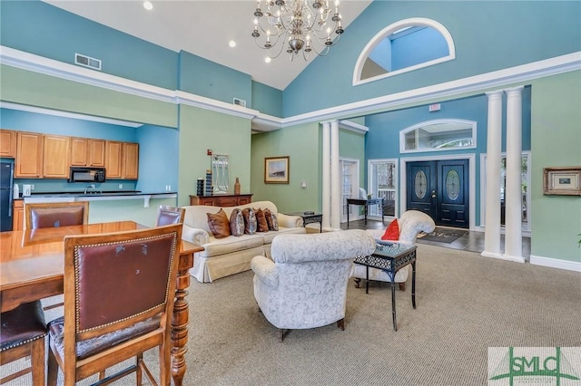 living room with ornate columns, light carpet, a chandelier, and high vaulted ceiling