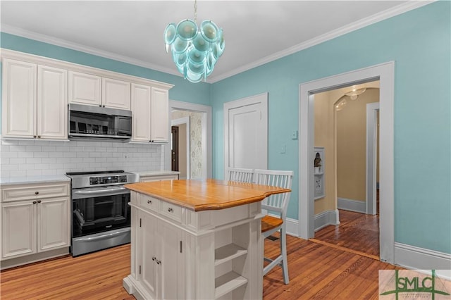 kitchen with stainless steel appliances, tasteful backsplash, light wood-style flooring, and white cabinets