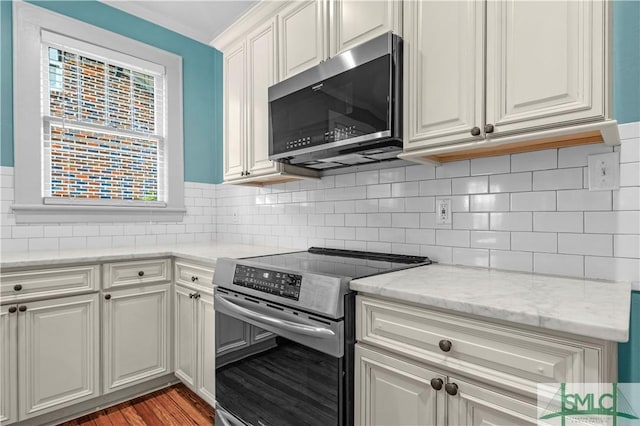 kitchen with light wood-style floors, tasteful backsplash, a wealth of natural light, and stainless steel appliances