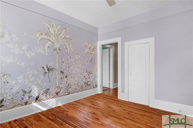 unfurnished room with baseboards, a ceiling fan, and hardwood / wood-style flooring