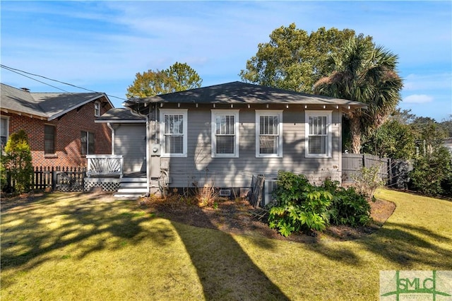 view of front of house with a deck, a front lawn, and fence