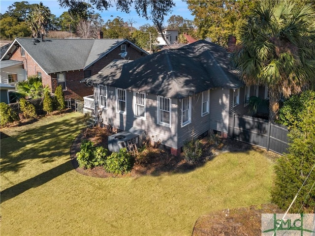 exterior space with cooling unit, fence, a yard, and a chimney