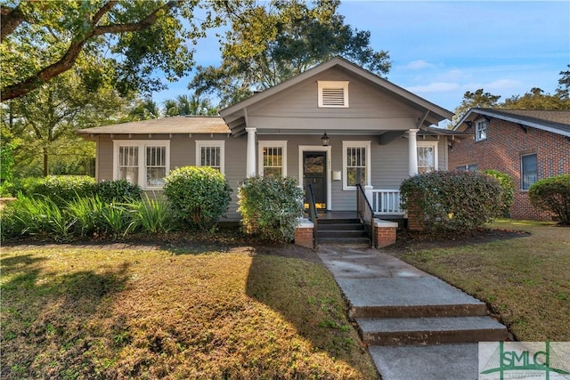 bungalow with a porch and a front yard