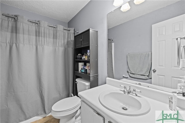 bathroom with a shower with curtain, vanity, toilet, and a textured ceiling