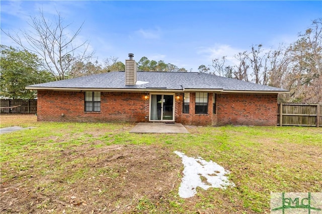 rear view of property featuring a yard and a patio area