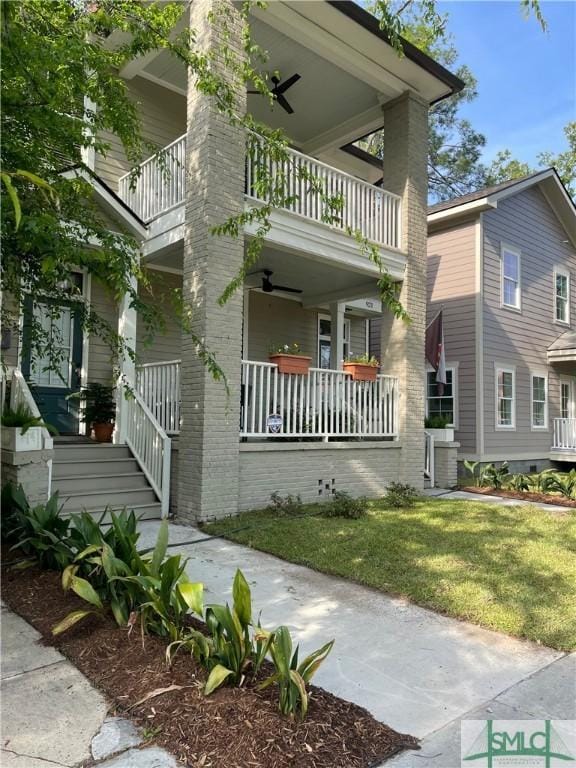 exterior space featuring a porch, a balcony, a front yard, and ceiling fan