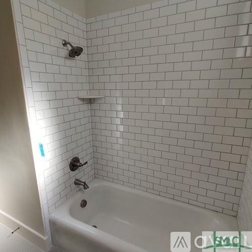 bathroom featuring tiled shower / bath