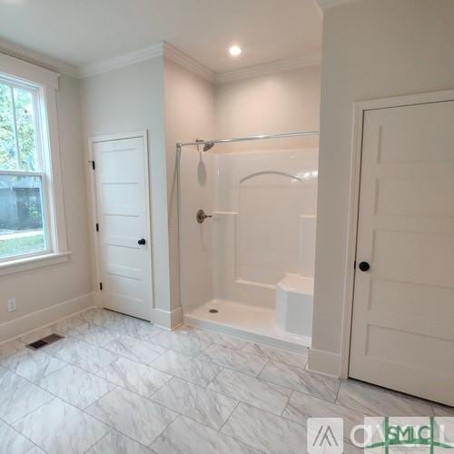 bathroom featuring ornamental molding and a shower